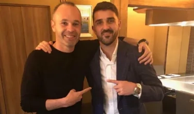 Andrés Iniesta recibiendo a David Villa. 