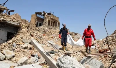 Miembros de los servicios transportan los cuerpos de varias personas encontradas bajo los escombros de un edificio en Mosul, Irak