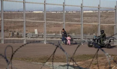 Imagen para ilustrar la nota. Una mujer migrante es detenida por la policía estadounidense hoy, en el muro fronterizo de la ciudad de Tijuana, en Baja California (México). 