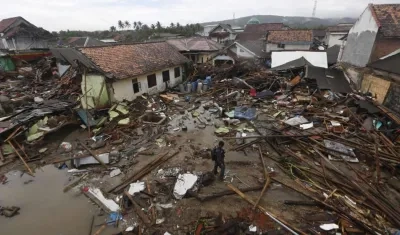 Los residentes locales caminan entre los escombros después de que un tsunami golpeó el Estrecho de Sunda en Sumur, Banten