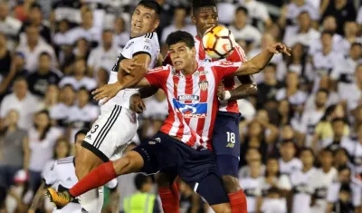 Jorge Arias y Yony González disputan el balón con Juan Patiño.
