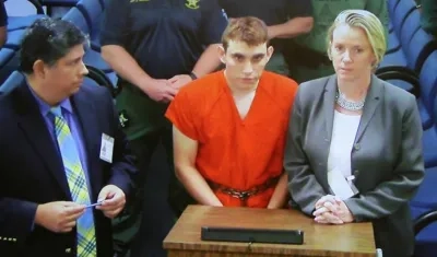 El sospechoso del tiroteo escolar Nikolas Cruz (c) comparece en video en la corte del condado de Broward ante la jueza Kim Theresa Mollica.