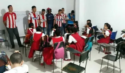 Hinchas llevando los útiles a los pequeños. 