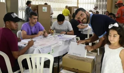 El senador Arturo Char deposita su voto, en compañía de su hija menor.