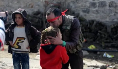 Un soldado del Ejército Libre de Siria se despide de su hija. Las cifras de niños muertos en la guerra aumentan.