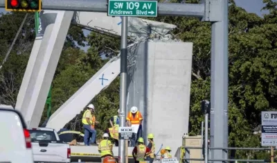 Obreros trabajando en la estructura caída del puente peatonal en Miami. 