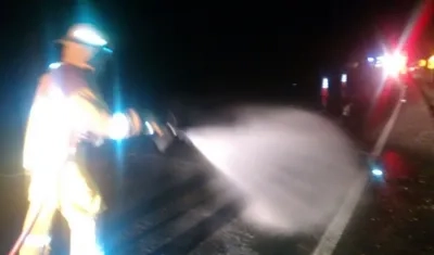 Bomberos limpian la vía por derrame de aceite.