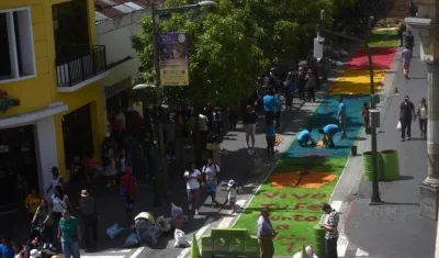  Voluntarios guatemaltecos participan en la elaboración de una alfombra de serrín.