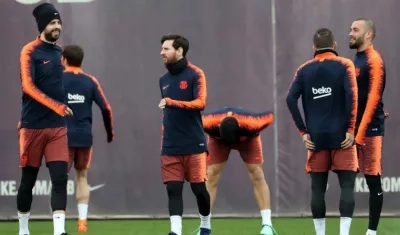 El delantero argentino del del FC Barcelona, Lionel Messi (c) y su compañero Gerard Pïqué (i) durante el entrenamiento que realiza la plantilla barcelonista para preparar el partido de liga que disputarán mañana ante el Sevilla FC.
