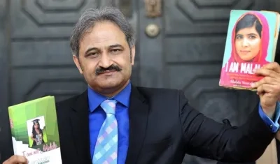 El presidente de la Federación de Colegios Privados de Pakistán, Mirza Kashif Ali, muestra un par de libros, uno de ellos escrito por la Premio Nobel de la Paz, Malala Yousafzai.