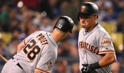 Joe Panik celebra tras su cuadrangular con Buster Posey. 