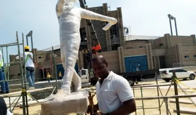 Édgar Rentería posa con la escultura y la estatua hecha a su honor. 
