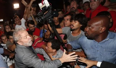 El expresidente brasileño Luiz Inácio Lula da Silva (i) abandona la sede del Sindicato de los Metalúrgicos de Sao Bernardo do Campo (Brasil) en medio de un tumulto para entregarse a las autoridades
