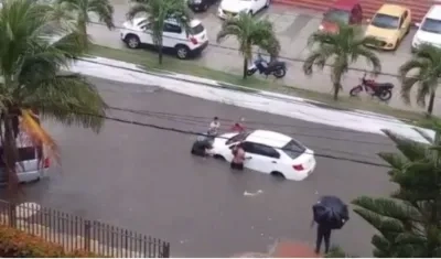Momento en que ciudadanos ponen a salvo un vehículo parqueado en la carrera 50.
