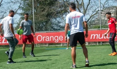 Juan Sebastián Cabal juega con la pelota ante la mirada de Robert Farah y Falcao García. 
