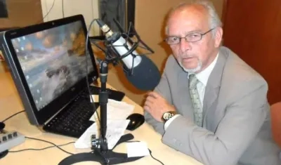 Alfredo Domínguez frente a dos valiosos elementos de trabajo: el micrófono y el computador.