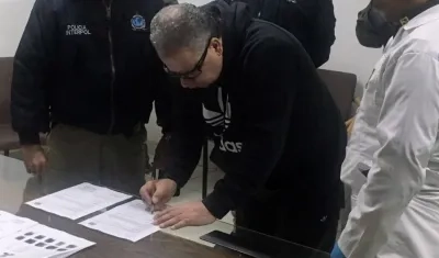 Exjefe paramilitar Daniel Rendón Herrera firmado documentos durante su extradición.