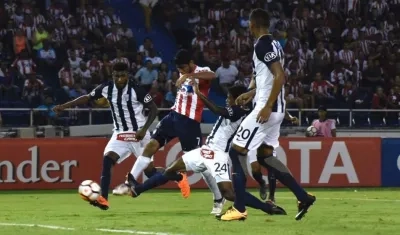 Luis Carlos Ruiz remata entre dos rivales para vencer al arquero Ángelo Campos.