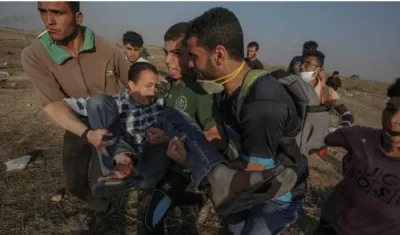 Manifestantes palestinos cargan un herido durante unos enfrentamientos con Israel en la zona Este de la Franja de Gaza.