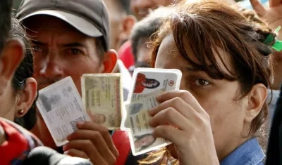 Una mujer venezolana muestra sus documentos.