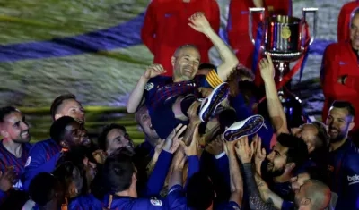 Andrés Iniesta es aupado por sus compañeros. 