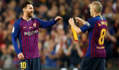 Andrés Iniesta pasa la cinta de capitán a Lionel Messi. 