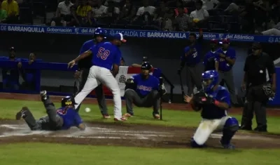 Un dominicano se desliza y toca el plato en el partido ante Puerto Rico, que ganaron 7-2.