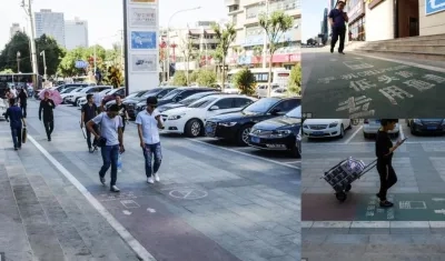 Muchas personas caminan mirando su celular por la calle.