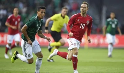 Héctor Moreno en acción de partido ante Christian Eriksen.