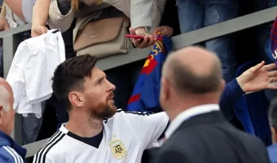 Lionel Messi firma autógrafos a los hinchas. 