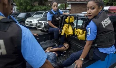 Un joven es detenido por miembros de la policía durante un acto celebrado por el pastor puertorriqueño Jorge Raschke en la Plaza de la Revolución en Managua.