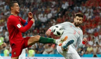 Gerard Piqué disputa la pelota con Cristiano Ronaldo. 