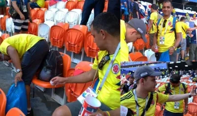 Colombianos recogiendo basura en el estadio.