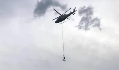 Un helicóptero lleva alimentos a los atrapados en el teleférico en Medellín.