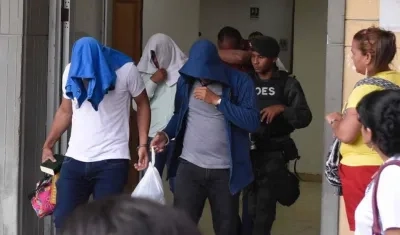 Tres de los 14 policías capturados saliendo de la audiencia.