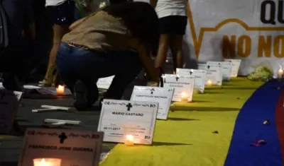 Velas encendidas, con cartelitos con los nombres de los líderes asesinados.