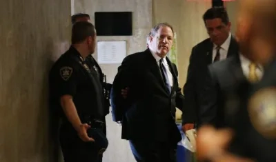 El productor de cine Harvey Weinstein escoltado por las autoridades.