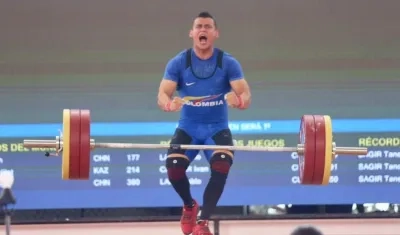 El pesista colombiano Hugo Montes celebra el levantamiento con el que ganó la medalla de oro.
