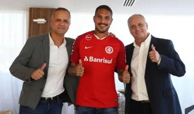 El futbolista peruano Paulo Guerrero (c) posando acompañado por el vicepresidente de fútbol del club Roberto Melo (i) y el presidente Marcelo Medeiros.