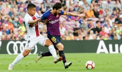 Cucho Hernández disputa la pelota con Lionel Messi