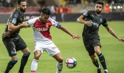 Falcao disputa la pelota con dos defensores. 