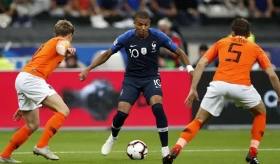 Kylian Mbappé ante la marca de dos defensas holandeses. 