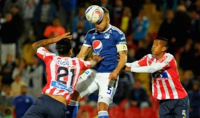 Jefferson Gómez y David Murillo disputando el balón con Andrés Cadavid.