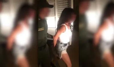 Mujer detenida siendo conducida por los agentes de la Policía. 