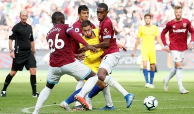El volante del Chelsea, Eden Hazard, frenado por defensores del West Ham. 