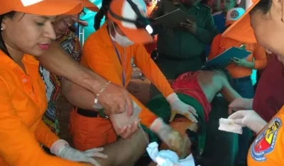 Voluntarios de la Defensa Civil atendiendo a uno de los lesionados.