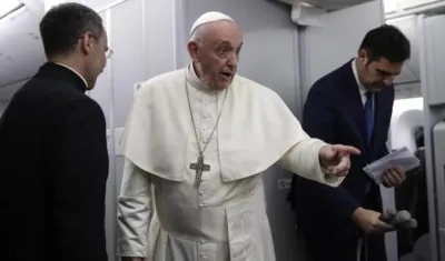 El Papa Francisco (c) junto al portavoz del Vaticano, Alessandro Gisotti (d), responde a las preguntas de los periodistas durante un vuelo desde Panamá a Ciudad del Vaticano.