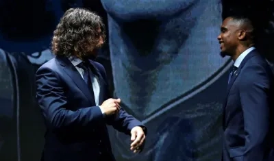 Charles Puyol y Samuel Eto'o dialogan en un evento. 