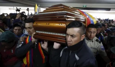 Policías retenidos ayudan a cargar el féretro con el cadáver de un dirigente de la Confederación de Nacionalidades Indígenas (Conaie) que murió ayer durante las protestas