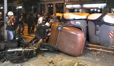 Varios manifestantes vuelcan contenedores en Barcelona.
